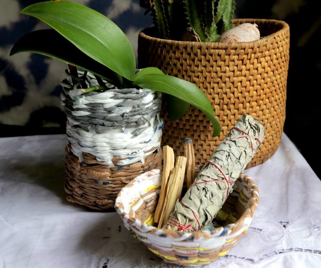 Woven baskets with plants, a sage bundle and palo santo sticks at a Nashville Night Market vendor stall